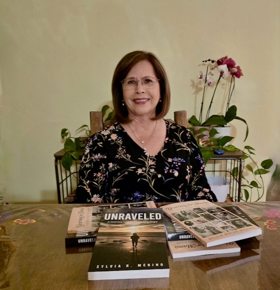 Sylvia seated at a table with copies of her books