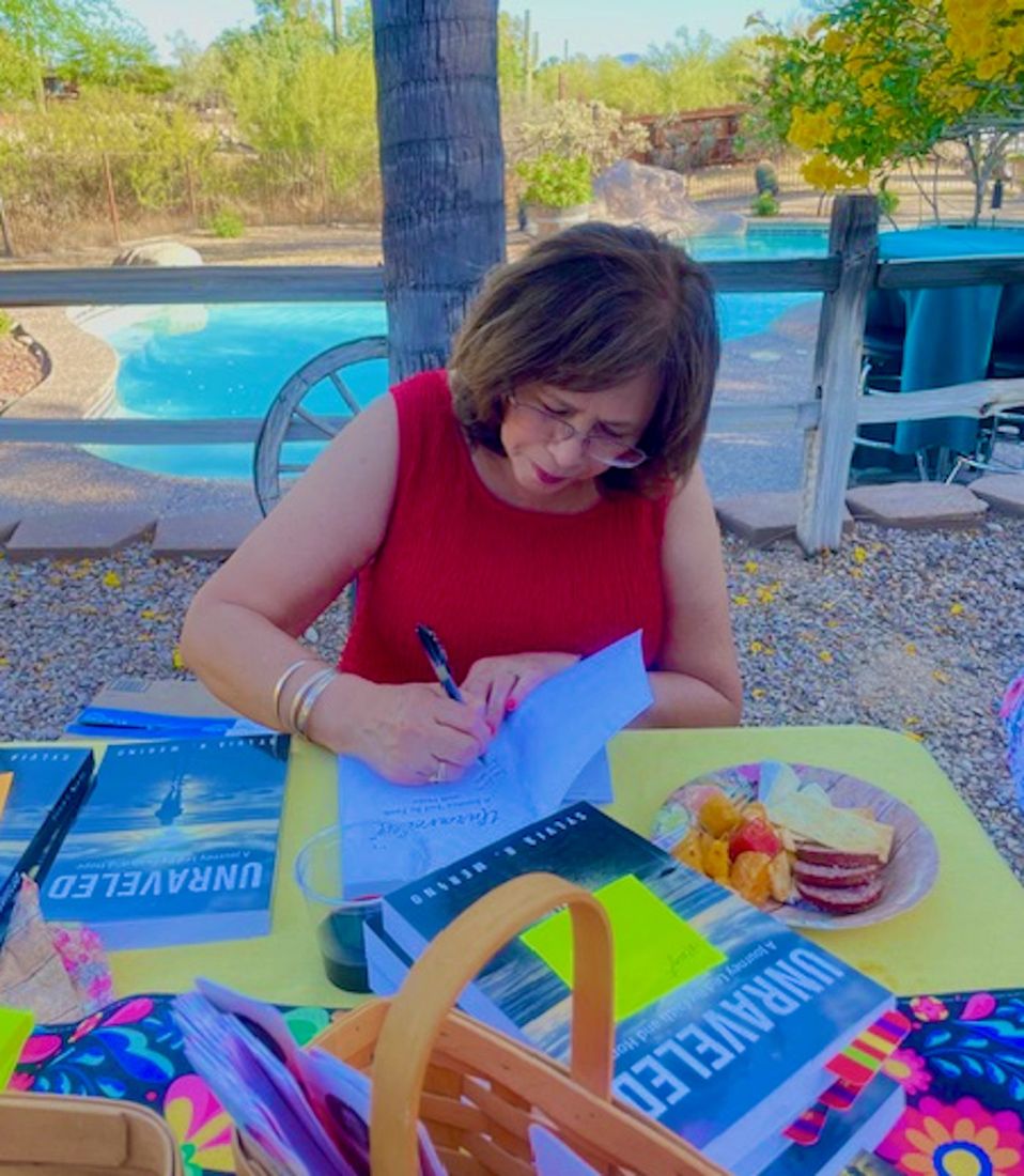 Sylvia signing books at an outdoor table