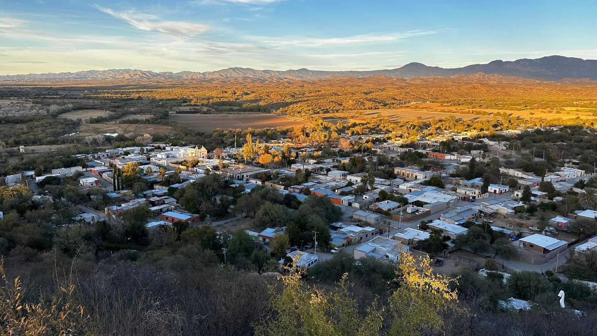 Rayón seen from the port, a small town in a valley with fall trees and mountains around it